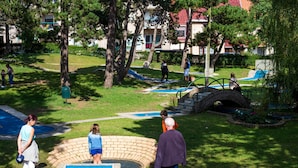 A park with a swimming pool, a brick structure, and a bridge. - Evancy Etoile des Dunes (Bray-Dunes)