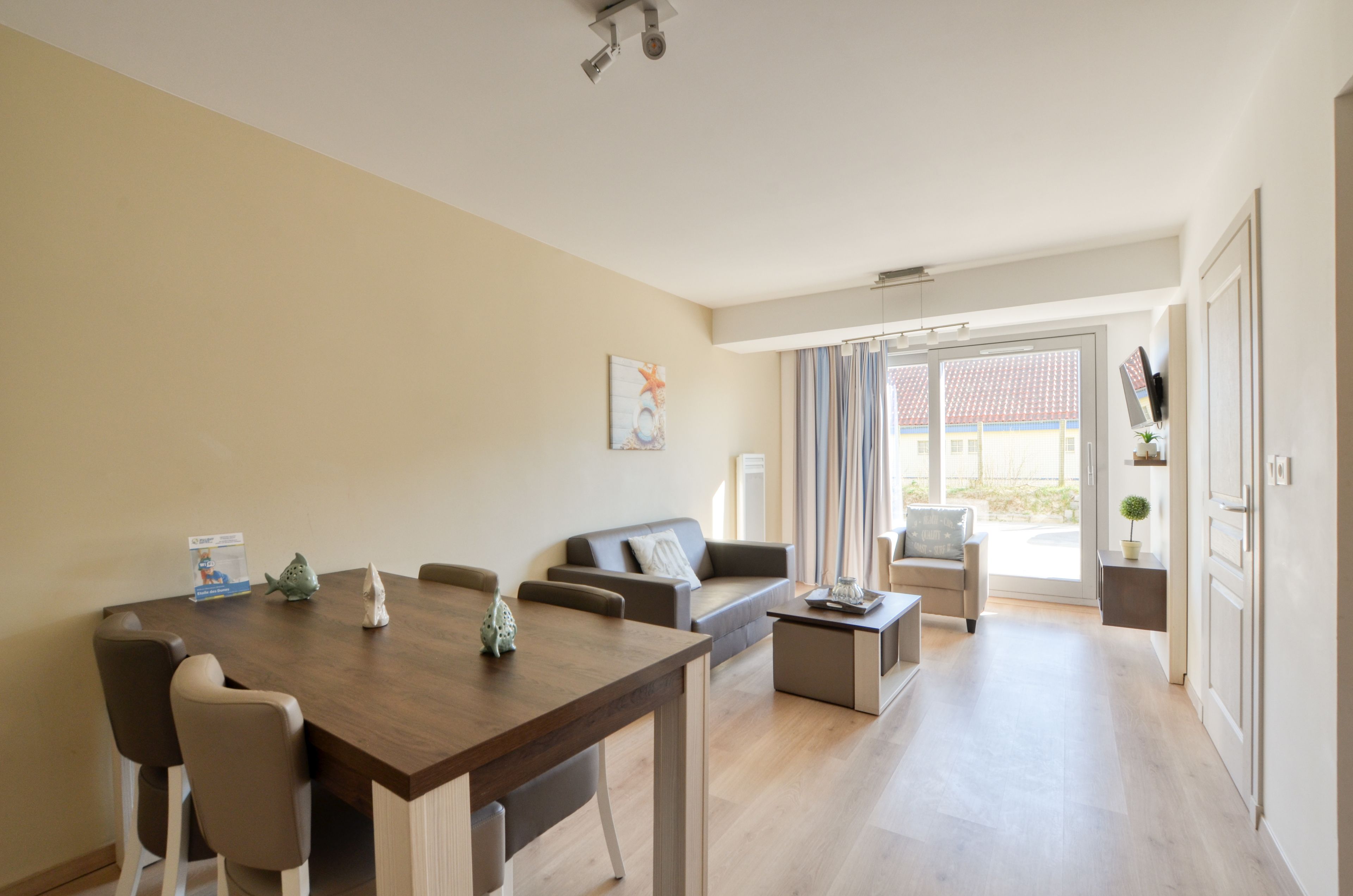 A modern living room with a dining area, a sofa, and a TV.