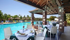 An outdoor dining area with a pool view, covered by a wooden roof, and stone pillars. - Valeria Dar Atlas Resort All Inclusive (Marrakech)