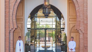 A hotel entrance with a brick facade, large arched doorway, and a hanging light fixture. - Valeria Dar Atlas Resort All Inclusive (Marrakech)