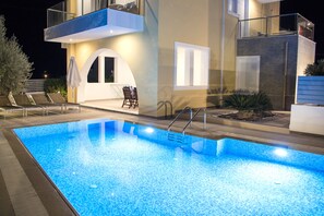 Una piscina con una casa moderna al fondo.
