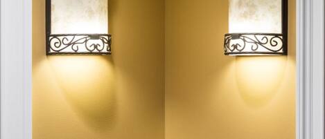 Two doors with numbers 111 and 112, each with a wall-mounted light fixture and a decorative number plate.