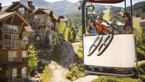 A cable car with passengers, wooden buildings, and a mountain backdrop. - Panorama Mountain Resort - Premium Condos and Townhomes (Panorama)