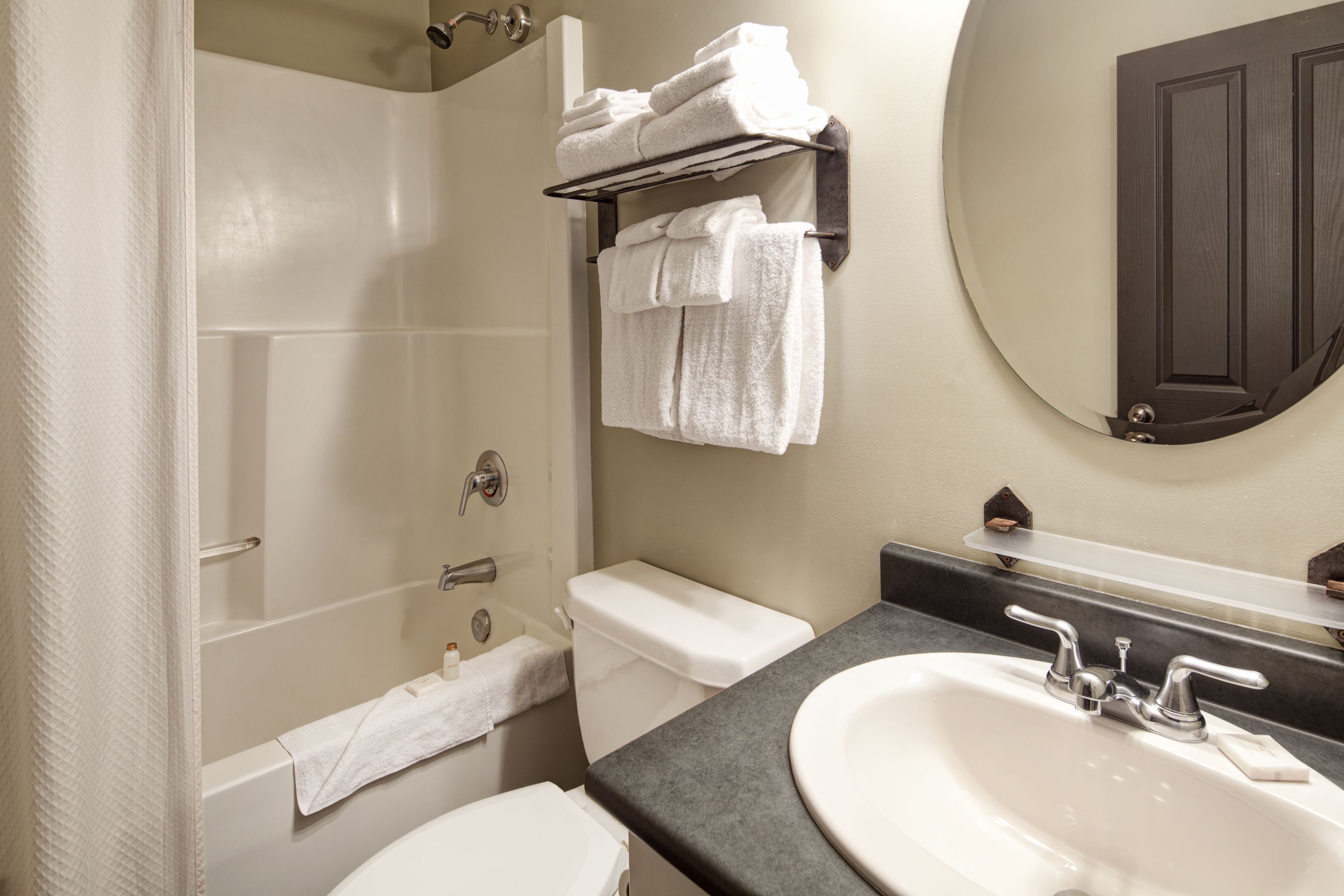A bathroom with a bathtub, toilet, sink, and towel rack.