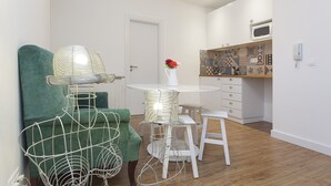 Een moderne keuken met witte kastjes, een magnetron en een decoratieve spatwand.