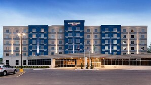 A Courtyard Marriott hotel with a modern facade, large windows, and a well-lit entrance. - Courtyard by Marriott Montreal West Island/Baie D'Urfe (Baie-D'Urfe)