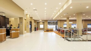 A spacious lobby with a reception desk, seating area, and a staircase. - Courtyard by Marriott Montreal West Island/Baie D'Urfe (Baie-D'Urfe)