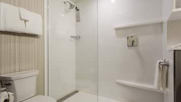 A modern bathroom with a glass-enclosed shower, a toilet, and a shelf with a towel.