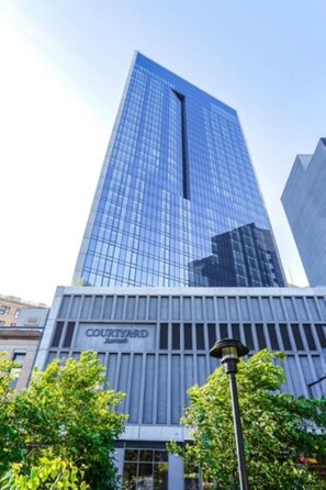 Un grand bâtiment moderne en verre, sur lequel on peut lire l’inscription « COURTYARD ».