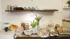 Una mesa de buffet con diversos alimentos, un tostador y una pequeña planta.