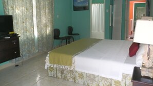 A hotel room with a bed, a desk, a television, and a window with curtains. - Paradise Beach Studio At Montego Bay Club (Montego Bay)