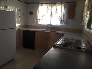 A kitchen with a dishwasher, sink, and stove. - Fitz Aruba 2 Bedroom Home (Noord)