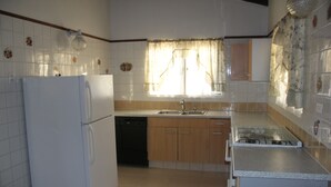 A compact kitchen with a refrigerator, dishwasher, sink, and stove. - Fitz Aruba 2 Bedroom Home (Noord)