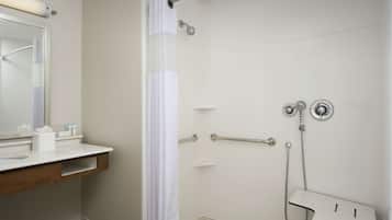 Un bagno con doccia, toilette, lavandino con specchio e porta asciugamani.