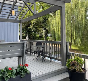 Eine Holzterrasse mit Gartenmöbeln und Blumentöpfen.