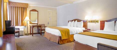A hotel room with two beds, a desk, a chair, a TV, and a lamp.