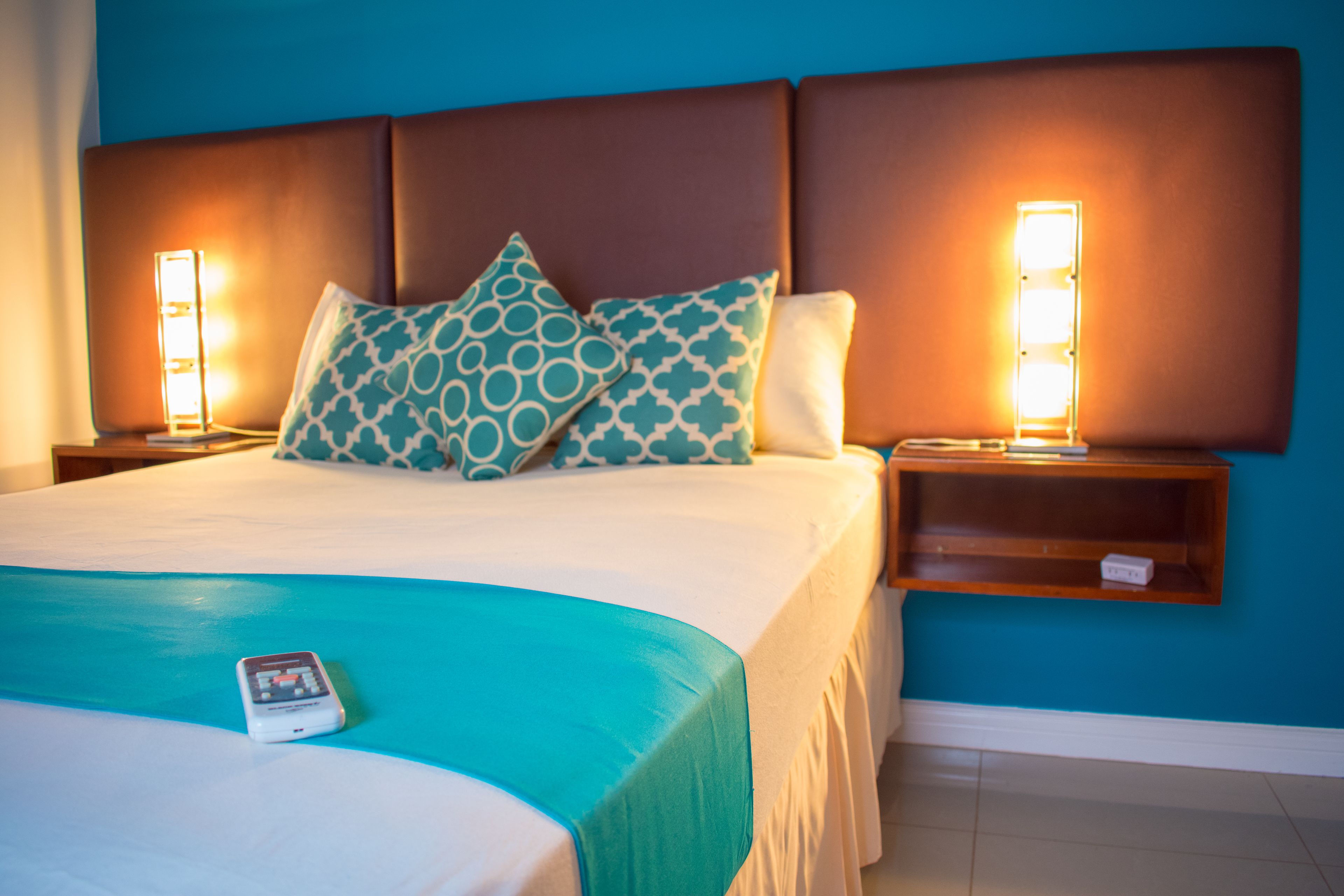 Ein Hotelzimmer mit einem großen Bett, zwei Nachttischen und einem Beistelltisch.