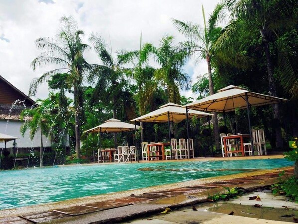 Alberca al aire libre y camastros