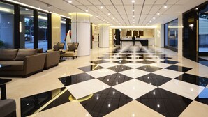 A hotel lobby with a checkered floor, seating area, reception desk, and large windows. - Shiny Ocean Hotel (Hualien City)