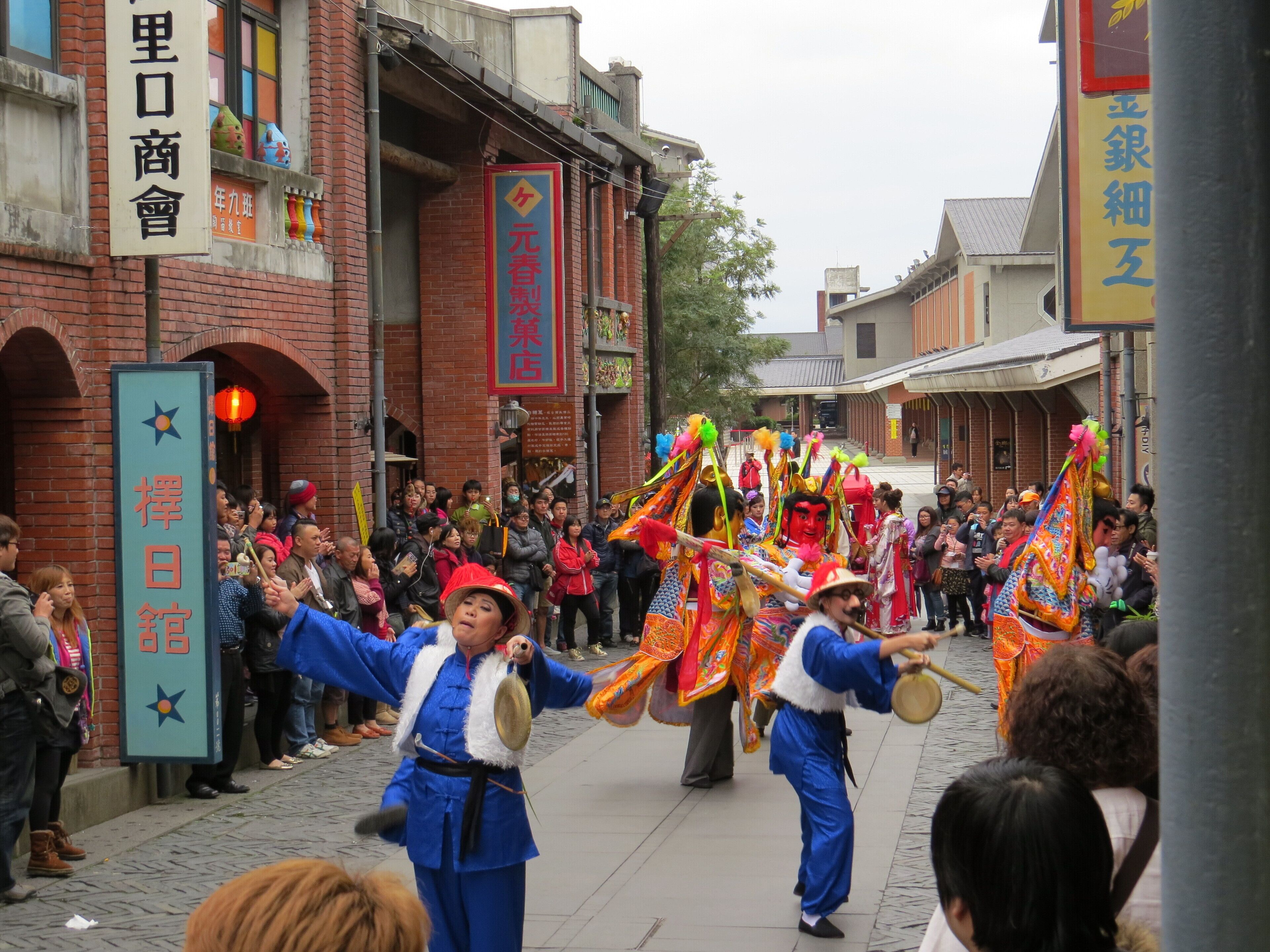 A street parade with performers in traditional costumes.