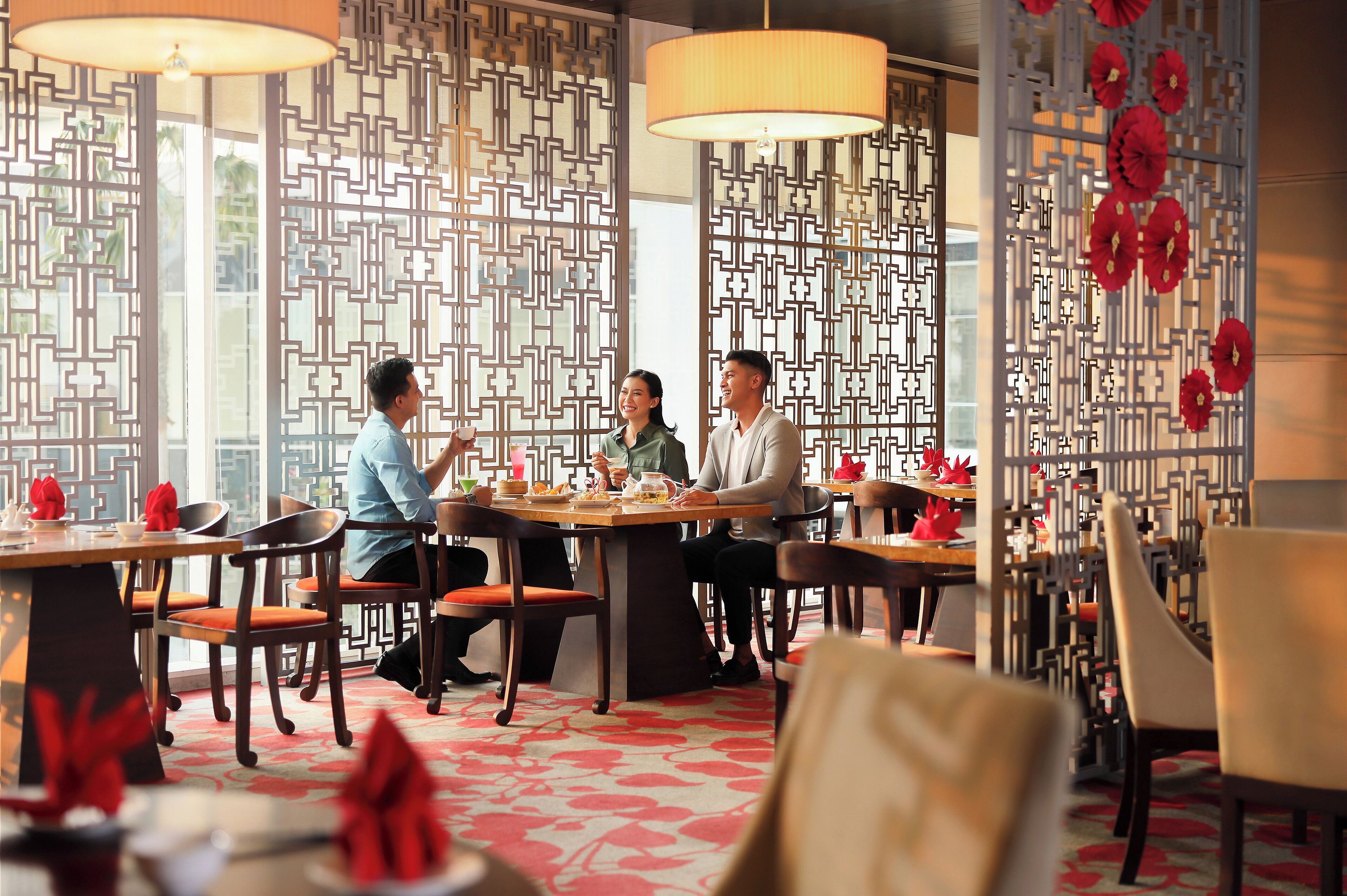 A restaurant with a traditional Asian design, featuring patterned screens and red decorations.