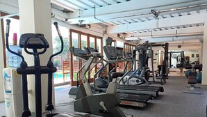 Une salle de sport équipée de tapis de course, de vélos elliptiques et de matériel de musculation.