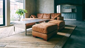 A modern living room with a sectional sofa, a coffee table, and a potted plant. - Kagelow Mt Fuji Hostel Kawaguchiko (Fujikawaguchiko)