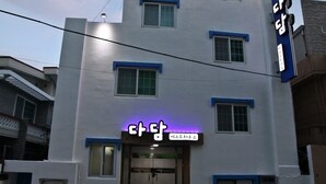 Un immeuble à plusieurs étages doté d’une façade moderne, avec une enseigne lumineuse bien visible à l’entrée.