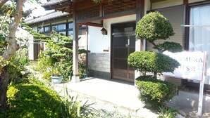 A traditional Japanese house with a wooden gate, potted plants, and a sign reading "KAMURA HOUSE". - Guest House Nakamura House (Oki)