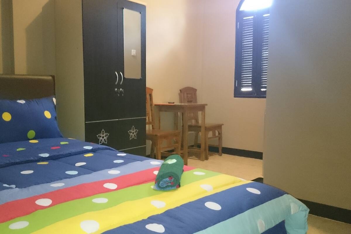 Ein Schlafzimmer mit einem Bett, einem Schreibtisch und einem Stuhl.