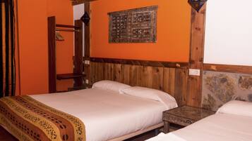 Una habitación con una cama de madera, una pared de piedra y un techo de madera.