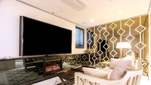 Una sala moderna con un televisor de pantalla plana grande, una chimenea y un separador decorativo.