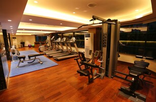 Una palestra con tapis roulant, ellittiche e attrezzature per pesi.