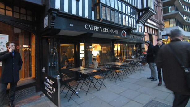 Ein Café namens Caffè Vergnano mit Außenbereich und einem Schild mit der Aufschrift 'Der beste Espresso Londons'.