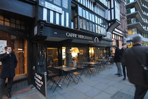 A cafe named Caffè Vergnano with outdoor seating and a sign stating "The Best Espresso in London".