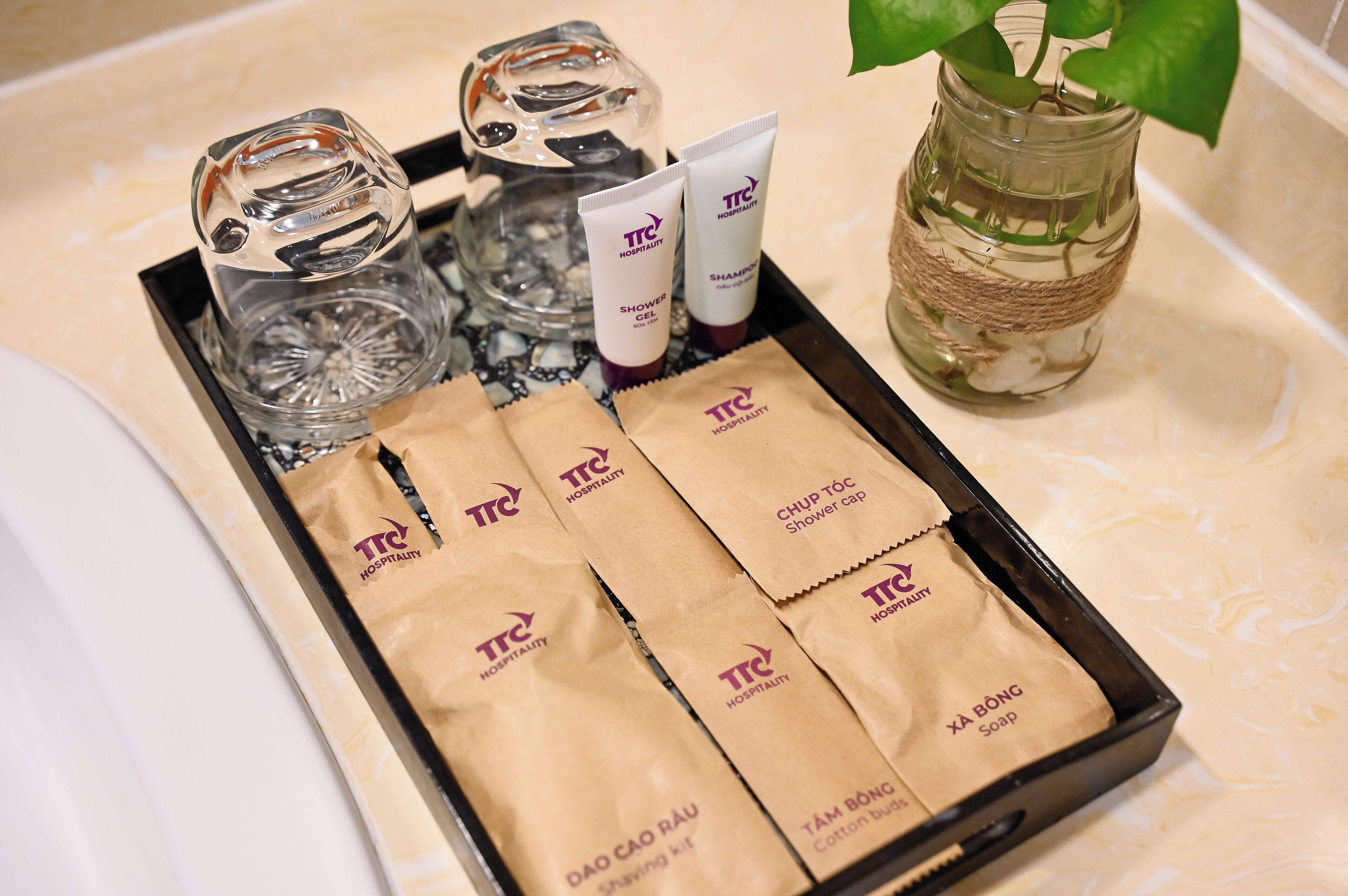 A tray with toiletries including shower gel, a shower cap, and soap.