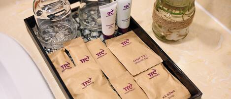 A tray with toiletries including shower gel, a shower cap, and soap.