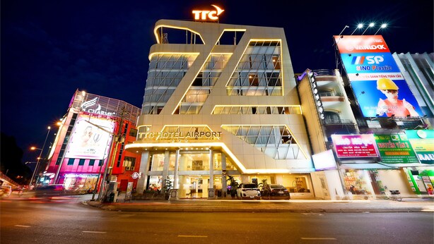 Un hotel de diseño moderno, con un llamativo letrero 'TTC' en la parte superior y un gran cartel que dice 'Hotel Airport'.
