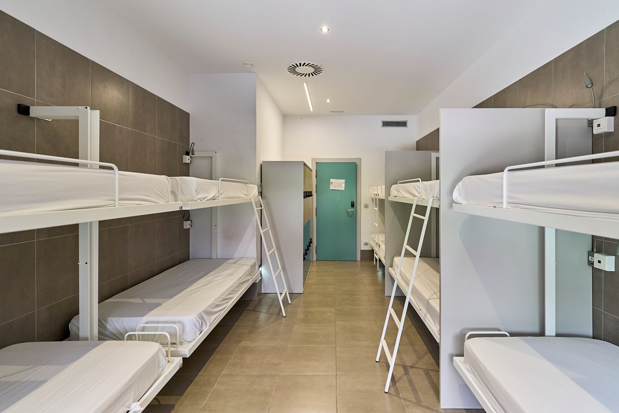 Un dormitorio con literas, una puerta y una lámpara.