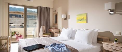 A hotel room with a bed, a desk, a chair, a window with a view, and a balcony.
