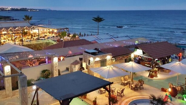 A beachfront hotel with outdoor seating and a pool area. - Malliotakis Beach Hotel by Checkin (Hersonissos)