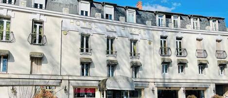 A multi-story building with a sign reading 'HOTEL DU RIVAGE.'