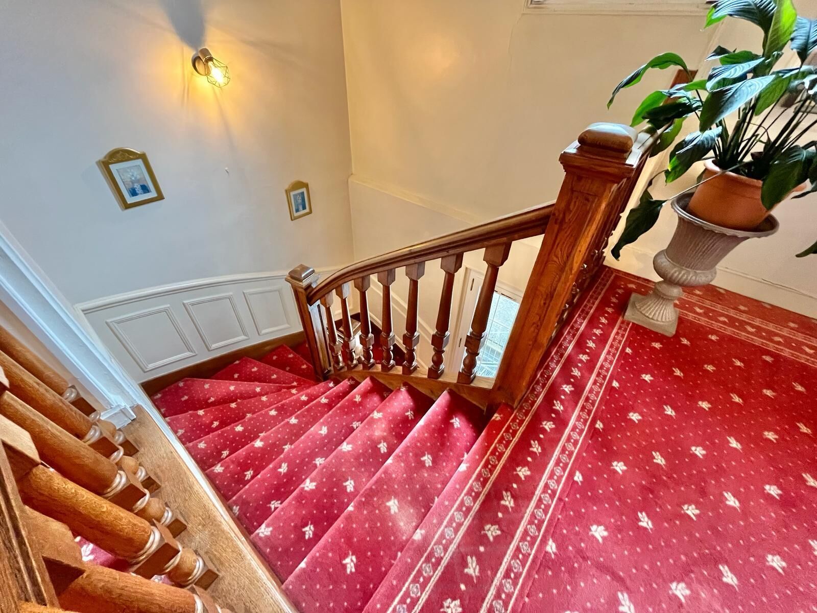 A staircase with red carpeted steps and wooden railings.