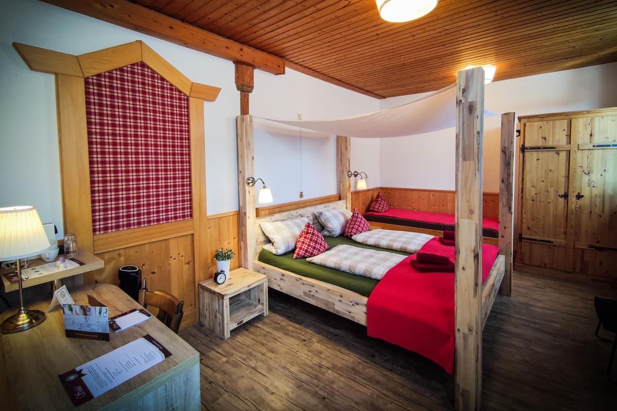 A wooden room with a bed, a desk, and a wardrobe.
