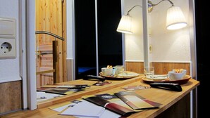 A hotel room with a wooden desk, a mirror, and two lamps. There are papers, a remote control, and a tray with cups and a plate on the desk. - Hotel Landgasthof Sonne (Mahlberg)