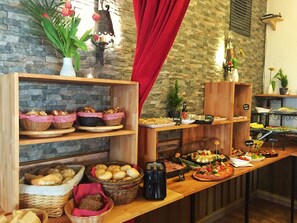 A buffet with various food items, including bread, pastries, and salads, displayed on wooden shelves and tables. - Hotel Landgasthof Sonne (Mahlberg)