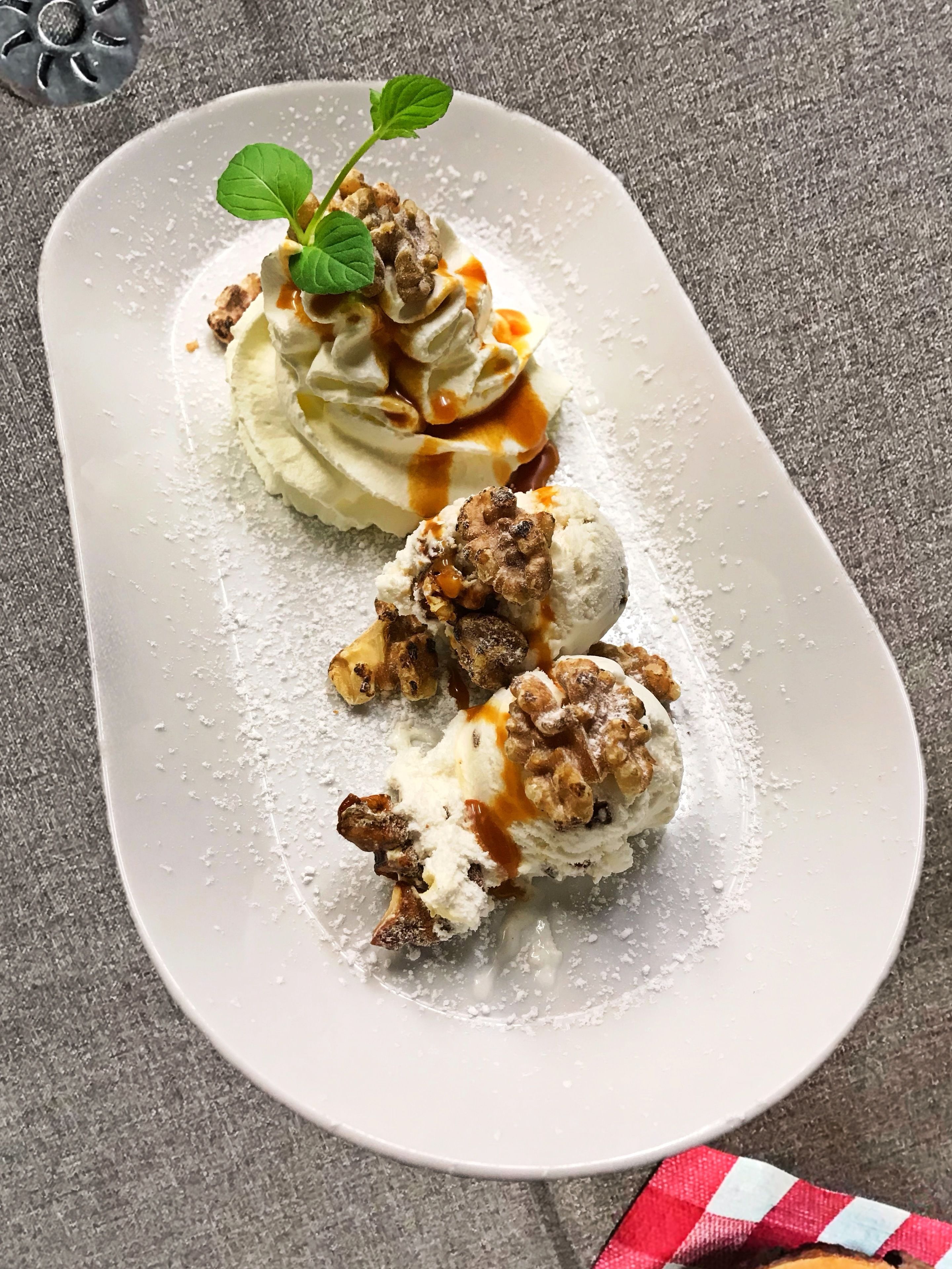 A dessert plate with ice cream and caramel sauce.