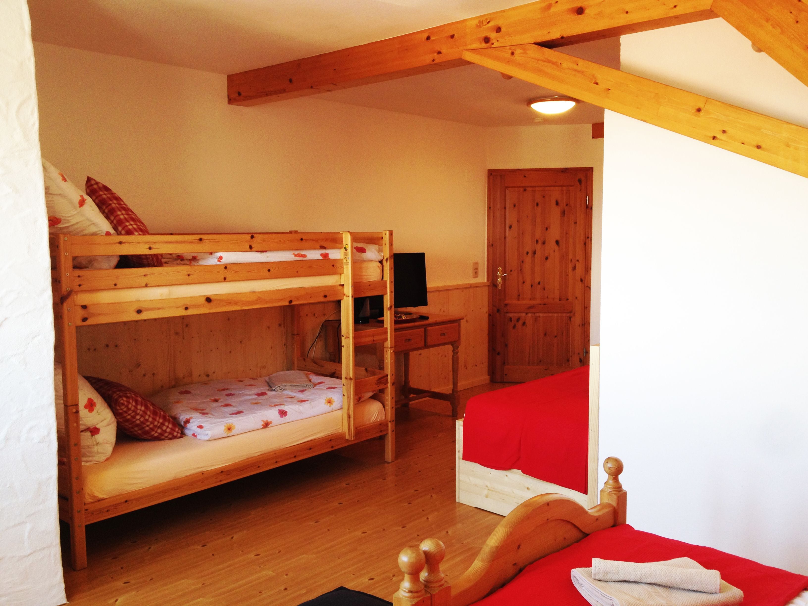 Quarto com beliche, escrivaninha e armário.