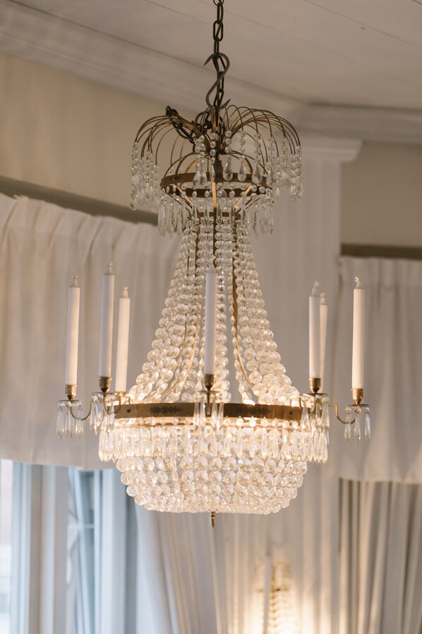 Um candelabro com várias lâmpadas que lembram velas e detalhes em cristal.