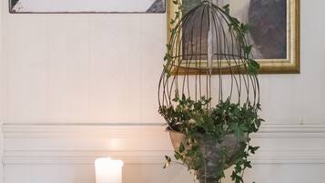 Une enseigne de bar, un tableau encadré, une bougie et une plante sur une table en bois.